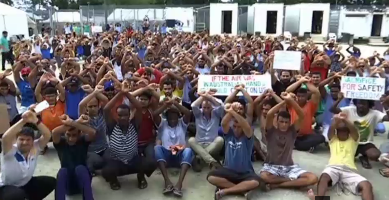 Manus refugees sit to refuse the order to leave the camp